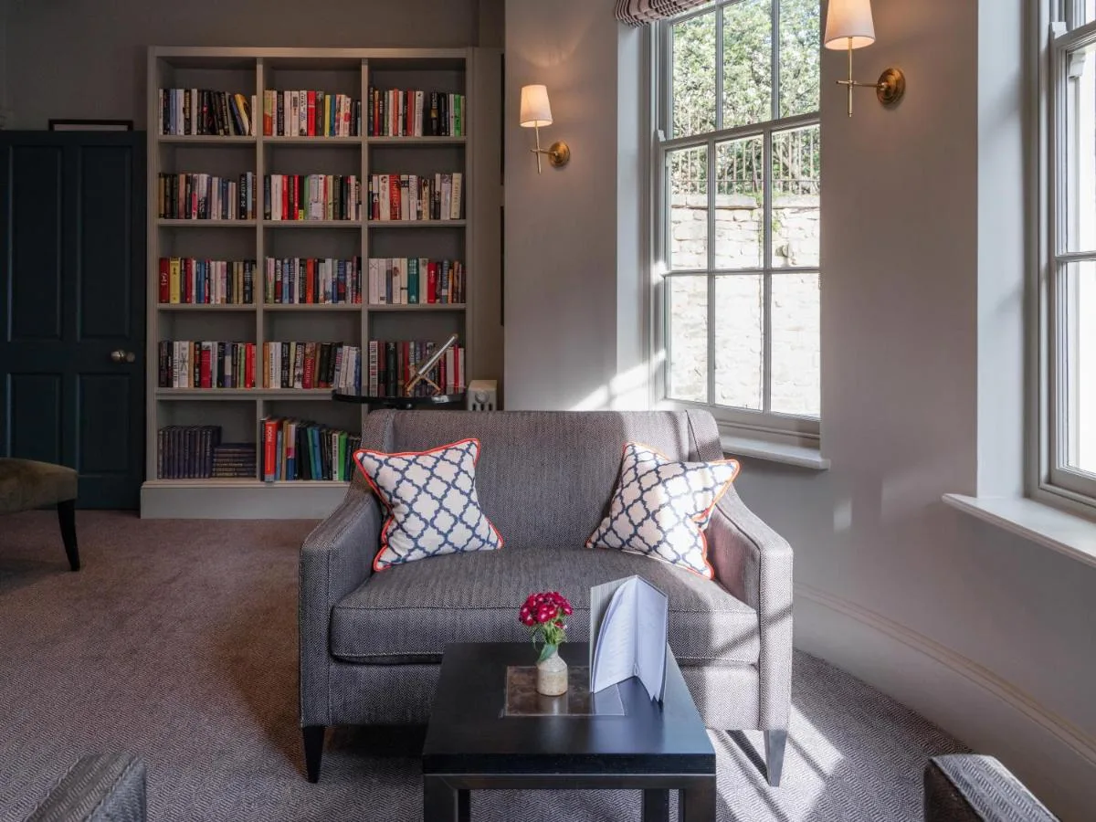 a living room with a couch and a book shelf at Old Bank Hotel in Oxford