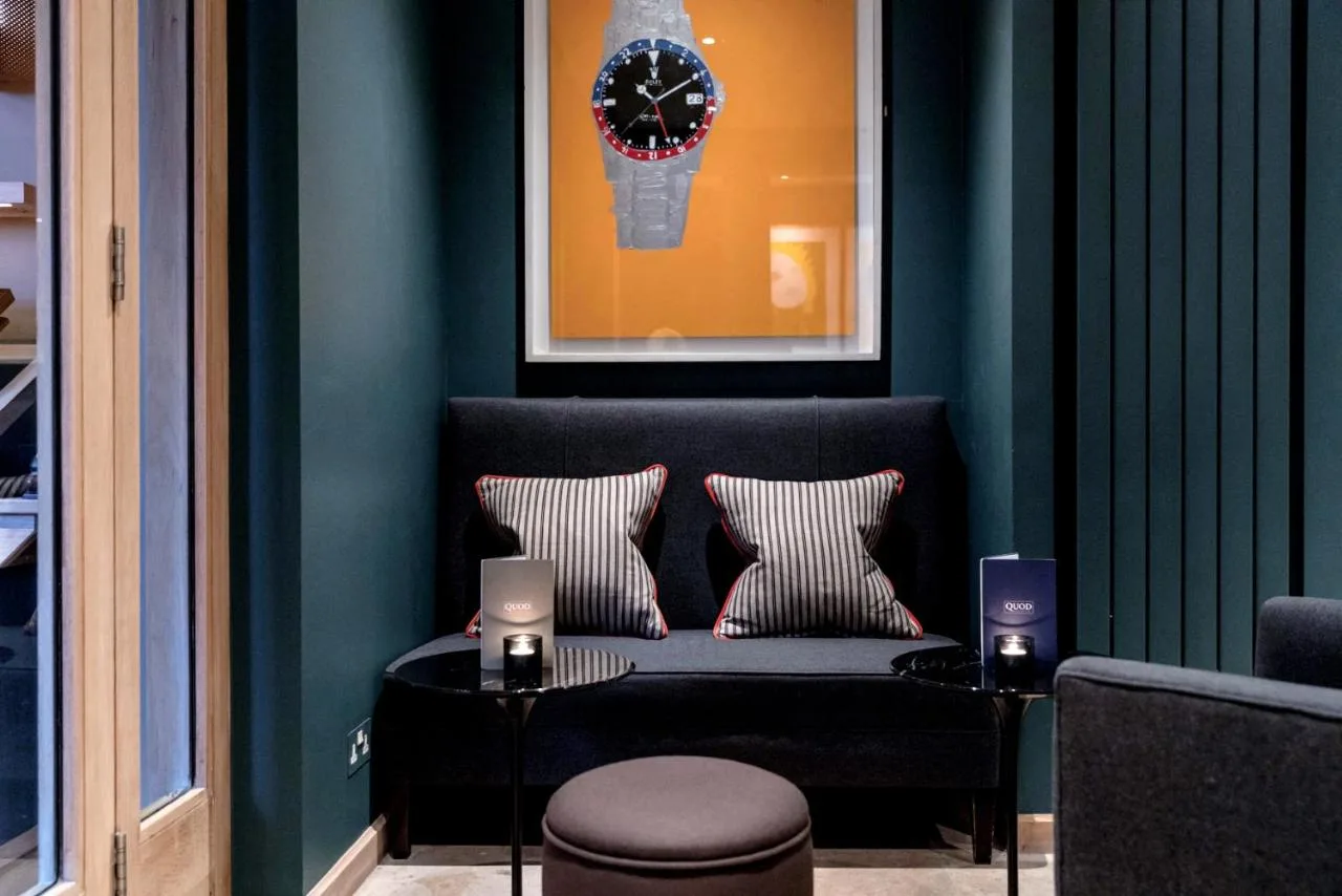 a blue room with a couch and a clock on the wall at Old Bank Hotel in Oxford